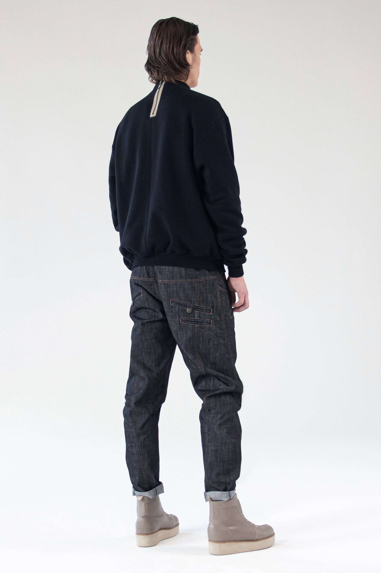 Detail close-up of the signature back zipper on the One Wolf ‘I Believe In You’ sweater.