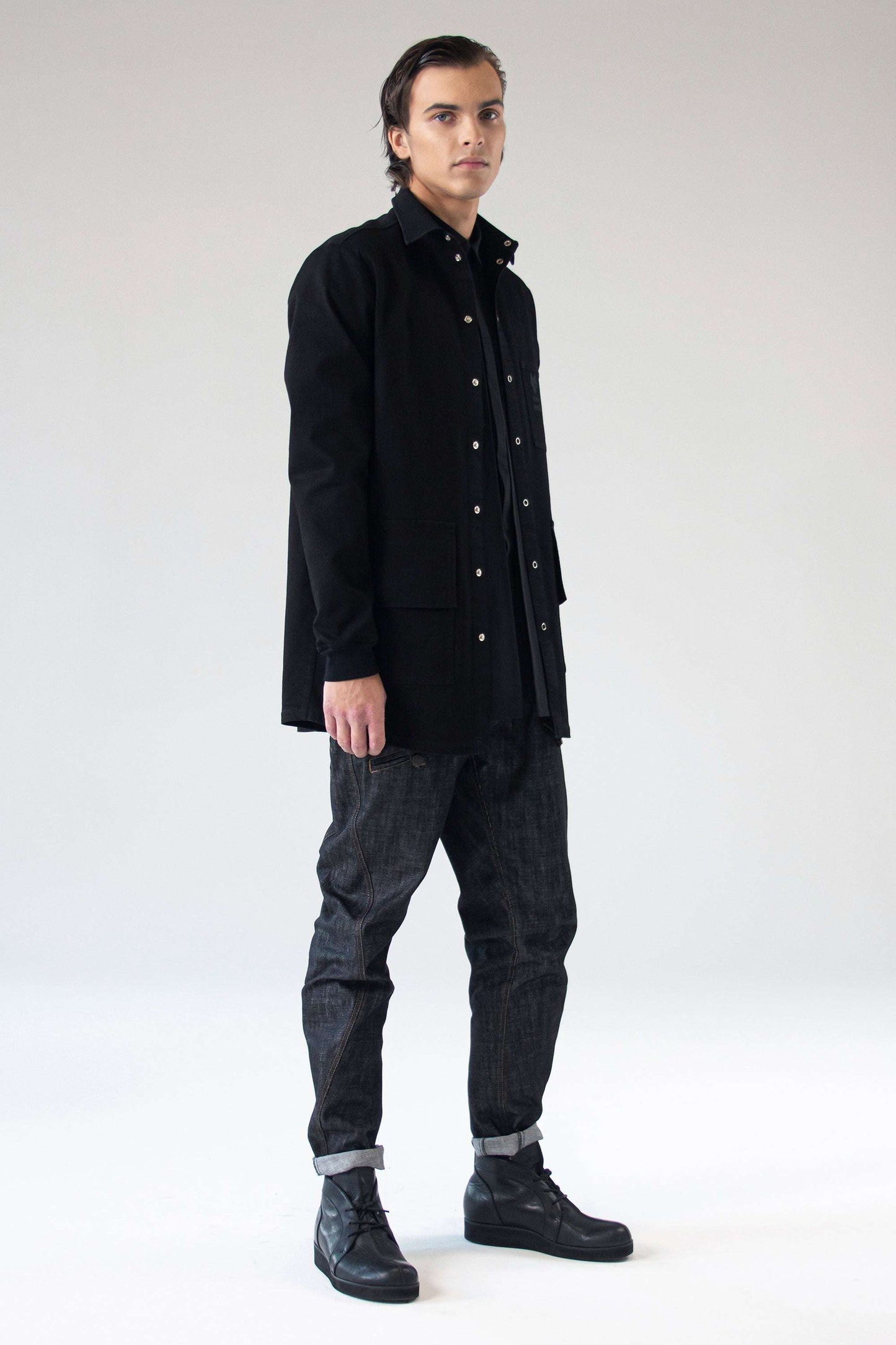 Male model wearing the One Wolf DESIRE denim jacket shirt with dark jeans, front view.