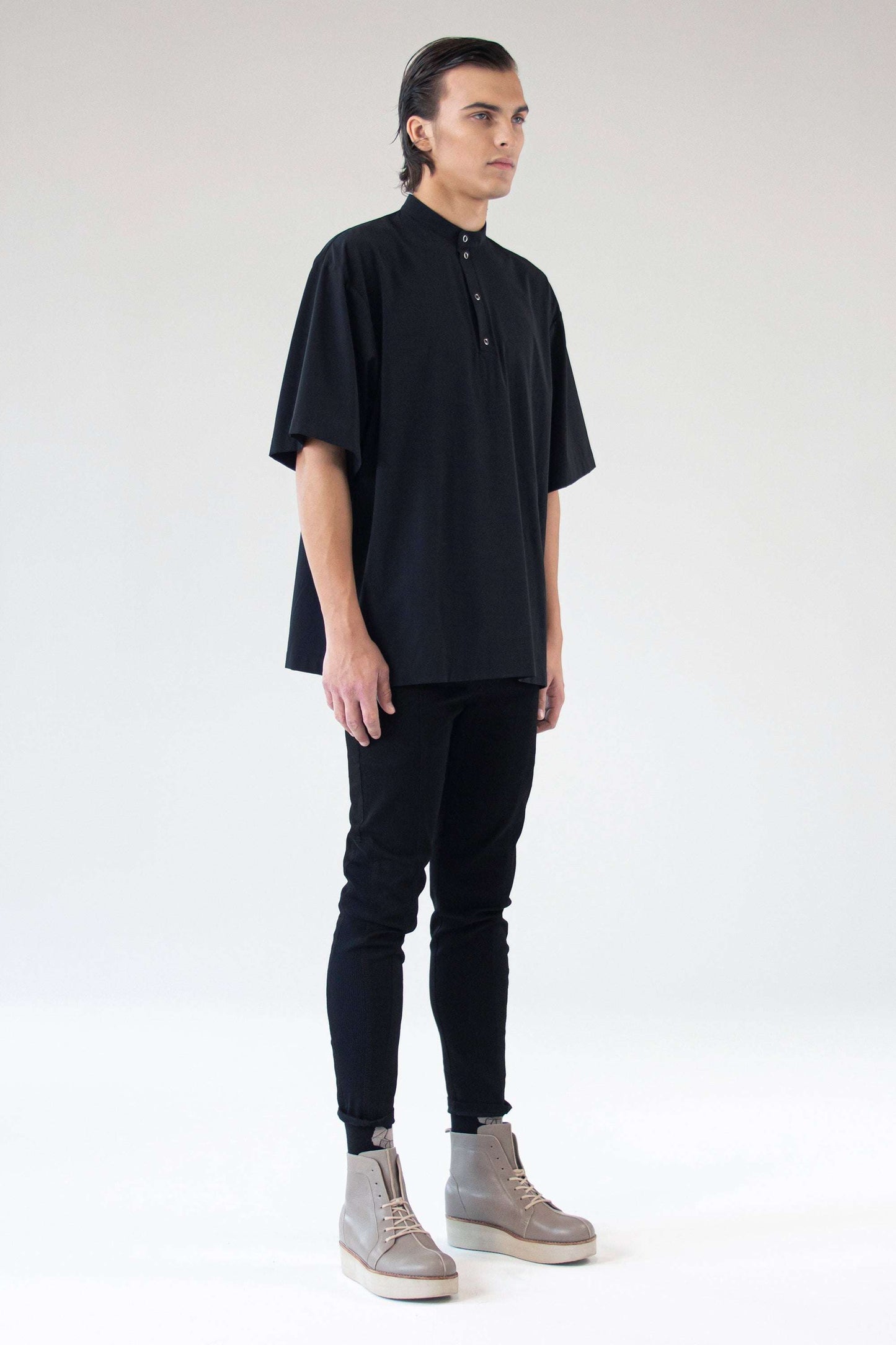 Model wearing shirt Holy in black, side angle showcasing stand collar